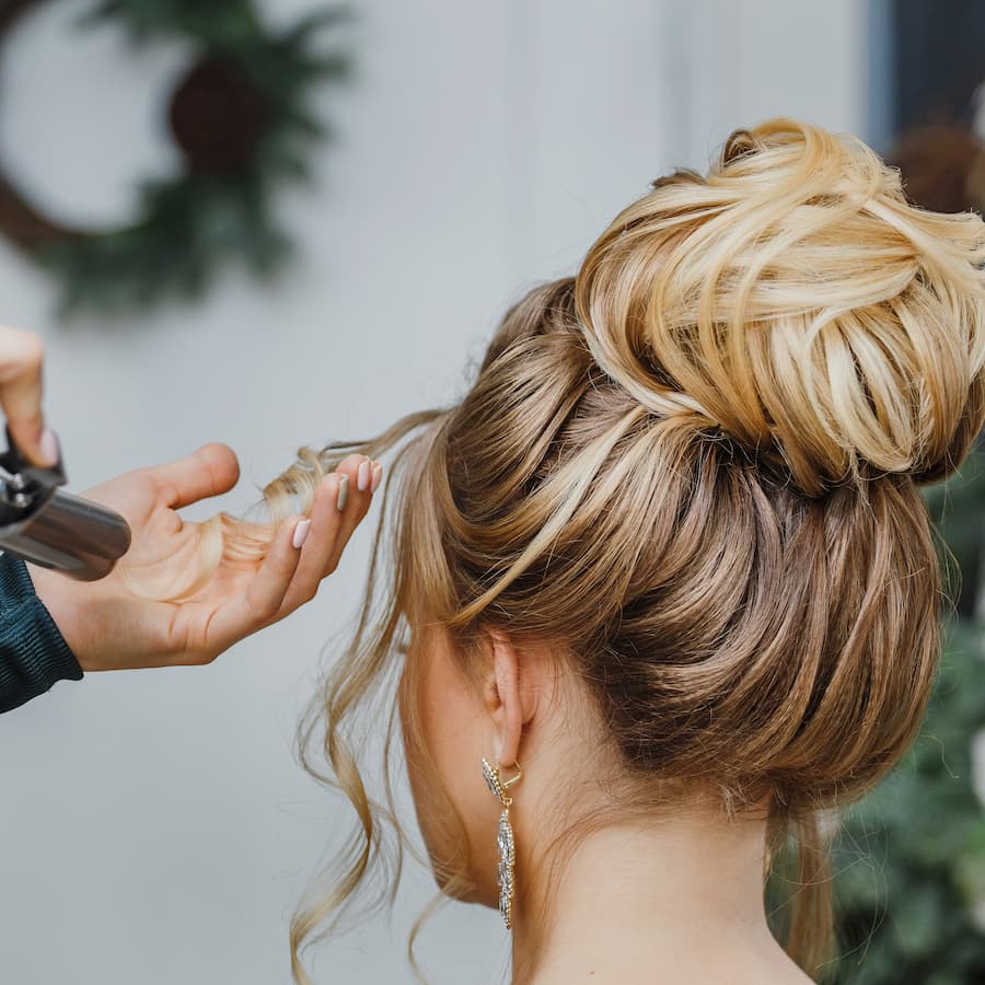 Hairdresser working at the beauty studio salon, making hair style.